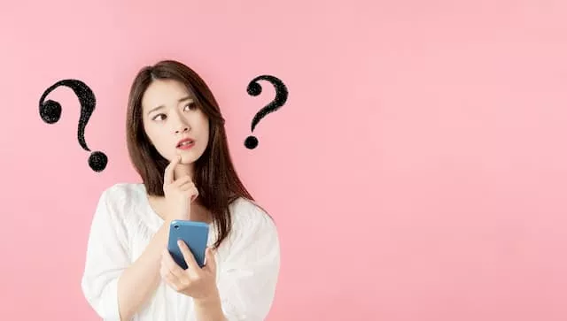 スマホを見ながら考える女性